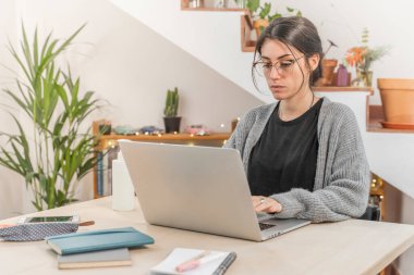 Coronavirus. Genç iş kadını evden izole edilmiş. Koronavirüs için karantinada olan bir kadın bilgisayarla çalışıyor. Evde kal. Küçük işletmeleri destekleyin. Kilitlenme.  