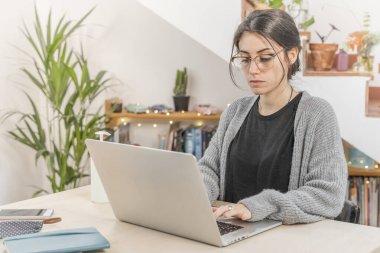 Coronavirus. Genç iş kadını evden izole edilmiş. Koronavirüs için karantinada olan bir kadın bilgisayarla çalışıyor. Evde kal. Küçük işletmeleri destekleyin. Kilitlenme.  