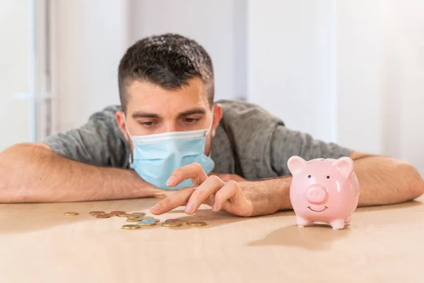 Coronavirus. Depressed and worried business man because impact on retail businesses shut down causing unemployment financial distress. Save money. Quarantine. Isolated. Piggy bank.