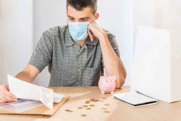 Coronavirus. Depressed and worried business man because impact on retail businesses shut down causing unemployment financial distress. Save money. Quarantine. Isolated. Piggy bank.