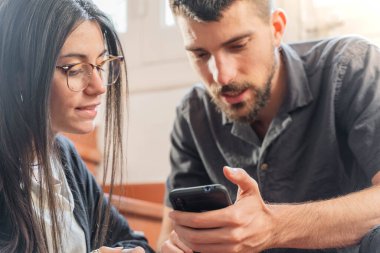 Coronavirus. Coronavirus sırasında evde cep telefonuna bakan birkaç arkadaş. Karantina konsepti. İşçiler. İzole edilmiş. 
