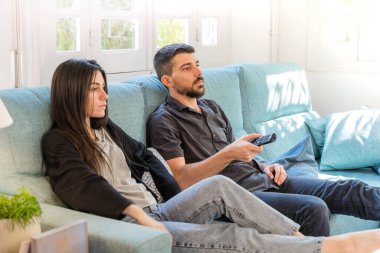 Coronavirus. Koronavirüs sırasında evde karantinada televizyon izleyen bir çift. Bu arada evdeki çift kanepede gülüp sohbet ediyor ve televizyon seyrediyor. - Eve. Evde kal.. 