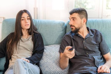 Coronavirus. Koronavirüs sırasında evde karantinada televizyon izleyen bir çift. Bu arada evdeki çift kanepede gülüp sohbet ediyor ve televizyon seyrediyor. - Eve. Evde kal.. 