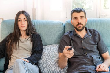 Coronavirus. Koronavirüs sırasında evde karantinada televizyon izleyen bir çift. Bu arada evdeki çift kanepede gülüp sohbet ediyor ve televizyon seyrediyor. - Eve. Evde kal.. 