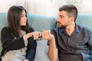 Coronavirus. Koronavirüs sırasında evde karantinada televizyon izleyen bir çift. Evdeki çift kanepede gülüyor ve televizyon kumandasını tartışıyor. - Eve. Evde kal.. 