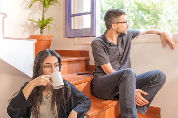 Coronavirus. Arkadaşları evde kahve yapıyor ve Coronavirus sırasında pencerenin yanında konuşuyorlar. Karantina konsepti. İşçiler. İzole edilmiş. Mola zamanı..