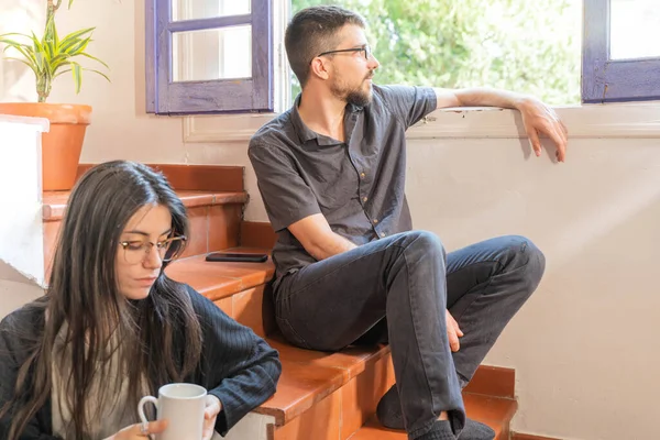 Coronavirus. Arkadaşları evde kahve yapıyor ve Coronavirus sırasında pencerenin yanında konuşuyorlar. Karantina konsepti. İşçiler. İzole edilmiş. Mola zamanı..