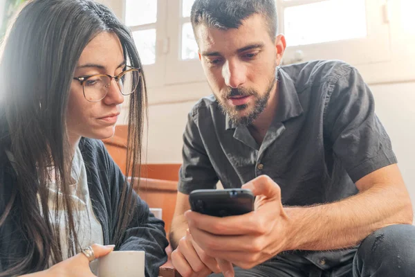 Coronavirus. Coronavirus sırasında evde cep telefonuna bakan birkaç arkadaş. Karantina konsepti. İşçiler. İzole edilmiş. 