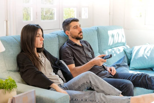 Coronavirus. Koronavirüs sırasında evde karantinada televizyon izleyen bir çift. Bu arada evdeki çift kanepede gülüp sohbet ediyor ve televizyon seyrediyor. - Eve. Evde kal.. 