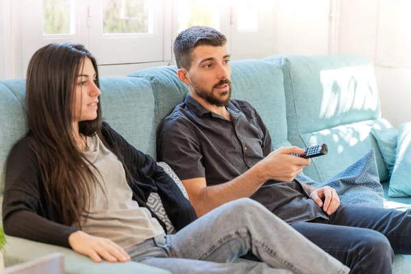 Coronavirus. Koronavirüs sırasında evde karantinada televizyon izleyen bir çift. Bu arada evdeki çift kanepede gülüp sohbet ediyor ve televizyon seyrediyor. - Eve. Evde kal.. 