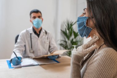 Coronavirus. Doktor sağlıksız kadını ziyaret ediyor. Doktor hastaya danışıyor. Önleme için yüz maskesi ve lastik eldiven kullanıyorlar. Hasta bakımı. Teşhisler. Coronavirus belirtileri