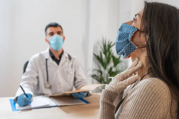 Coronavirus. Doktor sağlıksız kadını ziyaret ediyor. Doktor hastaya danışıyor. Önleme için yüz maskesi ve lastik eldiven kullanıyorlar. Hasta bakımı. Teşhisler. Coronavirus belirtileri