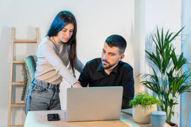 Bilgisayarlı küçük bir şirkette çalışan işçiler. Küçük bir şirket çalışıyor ve iş yapıyor. Küçük şirket ve takım çalışması konsepti. Küçük ofis. Karantina sırasında evde çalışıyorum. Coronavirüs. 