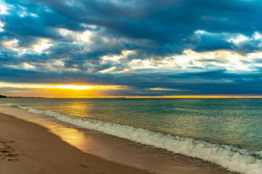 Mavi suları olan kumlu bir sahilde güzel bir gün batımı. Akdeniz 'in rahatlatıcı yaz manzarası. Temiz ve berrak okyanus. Gezegen kavramını sakla. Tatil ekran koruyucusu.