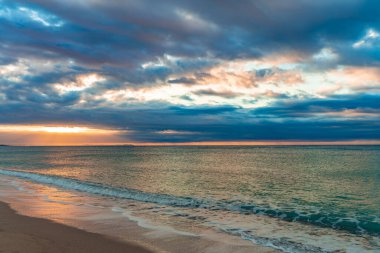 Mavi suları olan kumlu bir sahilde güzel bir gün batımı. Akdeniz 'in rahatlatıcı yaz manzarası. Temiz ve berrak okyanus. Gezegen kavramını sakla. Tatil ekran koruyucusu.