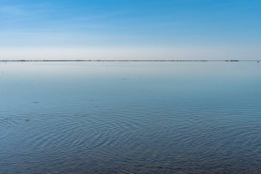 Akdeniz okyanus suyunda gökyüzü yansıması. Arka plan ekran koruyucusu dinleniyor. Gezegen kavramını sakla. Okyanusları kurtarın. Ahşap iskele. Ayna suyu sınırsız.