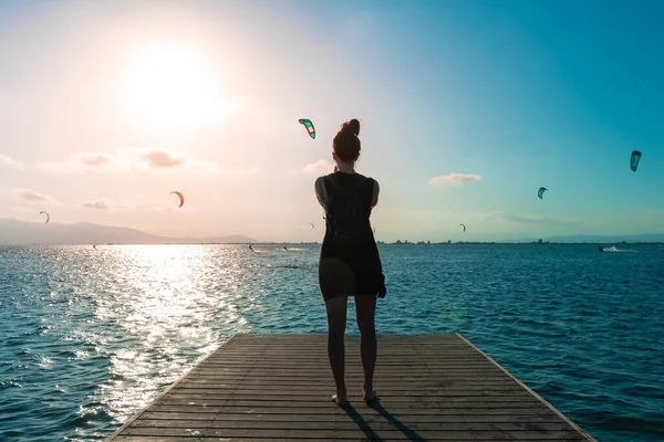 Vrouw Zwarte Zonnejurk Een Dek Kijkende Mensen Doen Kitesurf Sport — Stockfoto