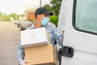Coronavirus. Koruyucu maskeli ve lastik eldivenli adam teslimat hizmeti veriyor. Karantina altında teslimat hizmeti, salgın hastalık, koronavirüs salgını. Ulaşım. Kahramanlar. 