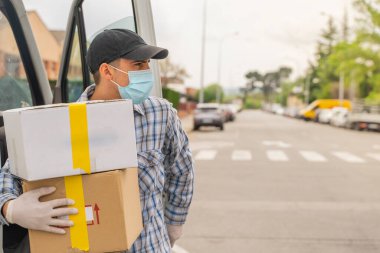 Coronavirus. Koruyucu maskeli ve lastik eldivenli adam teslimat hizmeti veriyor. Karantina altında teslimat hizmeti, salgın hastalık, koronavirüs salgını. Ulaşım. Kahramanlar. 