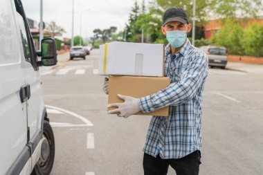 Coronavirus. Koruyucu maskeli ve lastik eldivenli adam teslimat hizmeti veriyor. Karantina altında teslimat hizmeti, salgın hastalık, koronavirüs salgını. Ulaşım. Kahramanlar. 