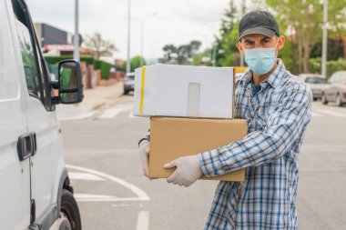 Coronavirus. Koruyucu maskeli ve lastik eldivenli adam teslimat hizmeti veriyor. Karantina altında teslimat hizmeti, salgın hastalık, koronavirüs salgını. Ulaşım. Kahramanlar. 