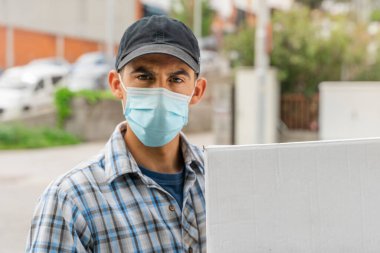 Coronavirus. Koruyucu maskeli ve lastik eldivenli teslimatçı portresi teslimat hizmeti veriyor. Karantina altında teslimat hizmeti, salgın hastalık, koronavirüs salgını. Ulaşım. Kahramanlar. 