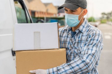 Coronavirus. Koruyucu maskeli ve lastik eldivenli adam teslimat hizmeti veriyor. Karantina altında teslimat hizmeti, salgın hastalık, koronavirüs salgını. Ulaşım. Kahramanlar. 
