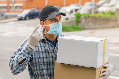 Coronavirus. Koruyucu maskeli ve lastik eldivenli adam teslimat hizmeti veriyor. Karantina altında teslimat hizmeti, salgın hastalık, koronavirüs salgını. Ulaşım. Kahramanlar. 