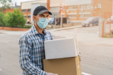 Coronavirus. Koruyucu maskeli ve lastik eldivenli adam teslimat hizmeti veriyor. Karantina altında teslimat hizmeti, salgın hastalık, koronavirüs salgını. Ulaşım. Kahramanlar. 