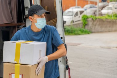Coronavirus. Koruyucu maskeli ve lastik eldivenli adam teslimat hizmeti veriyor. Karantina altında teslimat hizmeti, salgın hastalık, koronavirüs salgını. Ulaşım. Kahramanlar. 