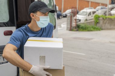 Coronavirus. Koruyucu maskeli ve lastik eldivenli adam teslimat hizmeti veriyor. Karantina altında teslimat hizmeti, salgın hastalık, koronavirüs salgını. Ulaşım. Kahramanlar. 