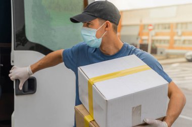 Coronavirus. Koruyucu maskeli ve lastik eldivenli adam teslimat hizmeti veriyor. Karantina altında teslimat hizmeti, salgın hastalık, koronavirüs salgını. Ulaşım. Kahramanlar. 