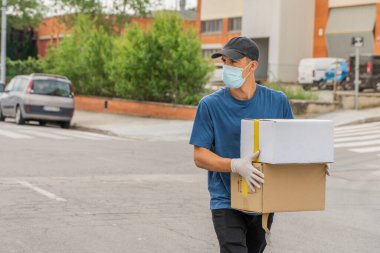 Coronavirus. Koruyucu maskeli ve lastik eldivenli adam teslimat hizmeti veriyor. Karantina altında teslimat hizmeti, salgın hastalık, koronavirüs salgını. Ulaşım. Kahramanlar. 