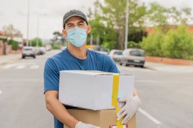 Coronavirus. Koruyucu maskeli ve lastik eldivenli adam teslimat hizmeti veriyor. Karantina altında teslimat hizmeti, salgın hastalık, koronavirüs salgını. Ulaşım. Kahramanlar. 