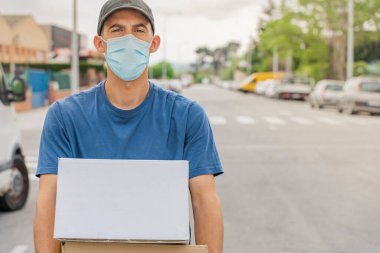 Coronavirus. Koruyucu maskeli ve lastik eldivenli adam teslimat hizmeti veriyor. Karantina altında teslimat hizmeti, salgın hastalık, koronavirüs salgını. Ulaşım. Kahramanlar. 