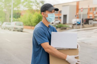Coronavirus. Koruyucu maskeli ve lastik eldivenli adam teslimat hizmeti veriyor. Karantina altında teslimat hizmeti, salgın hastalık, koronavirüs salgını. Ulaşım. Kahramanlar. 