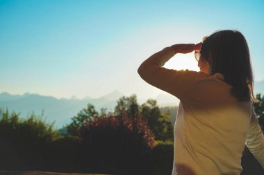 Güneşli bir günde inanılmaz doğa manzarasının tadını çıkaran güzel bir kadın. Sabah ışığıyla rahatlatıcı bir an.. 