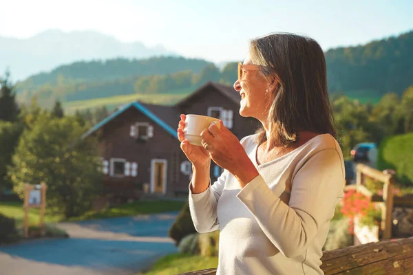 Beautiful woman enjoying amazing breakfast in nature during a sunny day with beautiful view. Healthy breakfast with hot coffee. Homemade. At home. Relaxing moment.