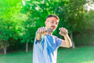 Farklı aktiviteler yapan komik bir sporcu. Açık havada poz veren genç bir sporcu. Yakışıklı eski sporcu eğitimi.. 