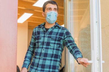 Coronavirus bitti, özgürlük konsepti adamı maskesini tutuyor ve güneş ışığı özgürlüğünün kapısını açıyor. Coronavirus bitti. Biz kazandık. Artık karantina yok. Derin nefes al. Maskeni çıkar..