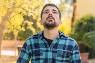 Coronavirus bitti, özgürlük kavramı. Güneş ışığında maskesini tutan adam özgürdür. Coronavirus bitti. Biz kazandık. Artık karantina yok. Derin nefes al. Maskeni çıkar..