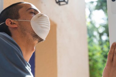 Coronavirus bitti, özgürlük konsepti adamı maskesini tutuyor ve güneş ışığı özgürlüğünün penceresini açıyor. Coronavirus bitti. Biz kazandık. Artık karantina yok. Derin nefes al. Maskeni çıkar. Tedavi.. 