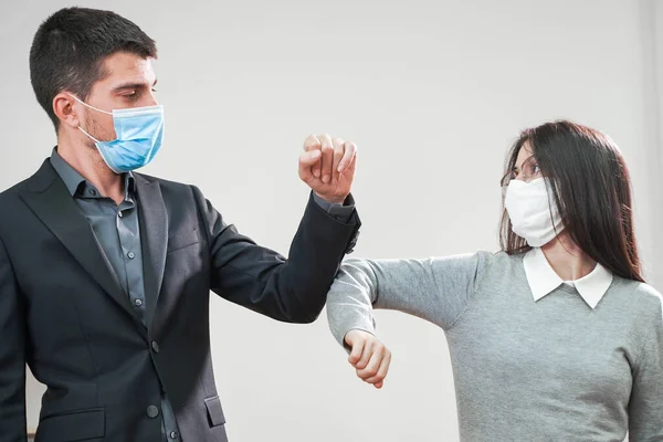 Coronavirus. Business workers wearing protective mask in a white background. Elbow greeting. Business workers with face masks back to work in office after lockdown. Small company concept.