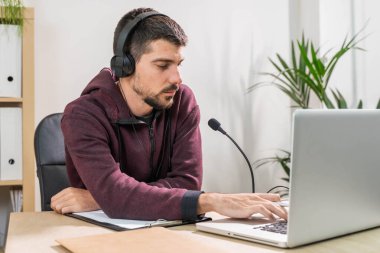 Bilgisayarda çalışan pazarlamacı. Ofiste yüz maskesi takmış bir kulaklıkla konuşuyor. Koronavirüs yüzünden evden izole edilmiş ve çalışıyor. İş çalışanı müşteri çağrılarına cevap veriyor. 