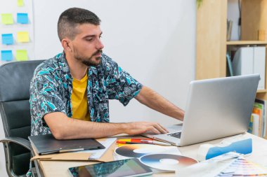 Başlangıç ofisinde dizüstü bilgisayarla çalışan sıradan bir iş adamı. Yapıştırma geçmişi olan bir iş adamı. Yaratıcı stüdyo. Modern ofisteki adam.