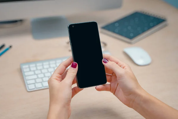 Beautiful woman hands close up cell phone mockup image black screen phone. Woman hands holding texting using mobile on desk. background empty space for advertise text. People contact marketing business, technology.