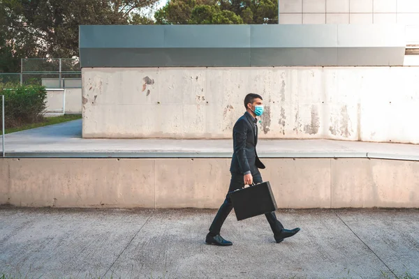 자신감 성공적 마스크와 가방을 사업가가 사무실 뒤에서 걷다가 눈길을 돌리고 — 스톡 사진