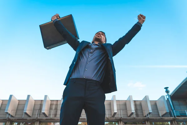 Confident and successful. Handsome young businessman looking away standing outdoors with blue sky in the background.