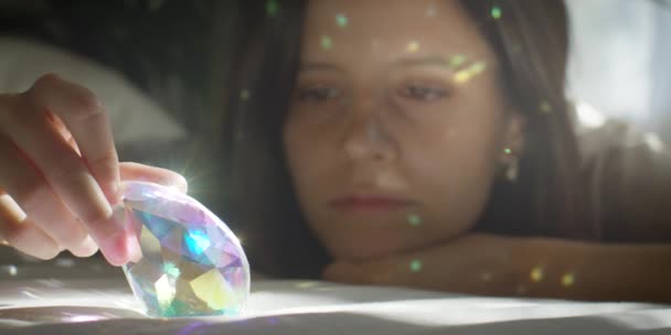 年轻女人玩玻璃棱镜 美丽的色彩效果 女孩面对特写镜头 4K慢动作 在家里放松一下 — 图库视频影像