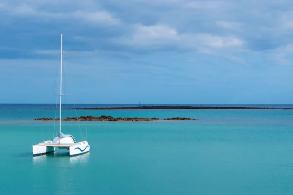 A photography of a catamaran in the ocean and overcast sky